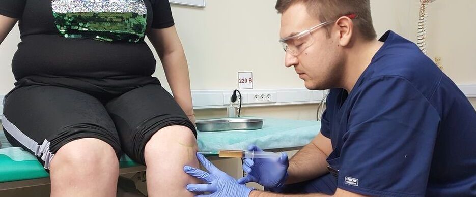 Zdravnik ortoped naredi intraartikularno injekcijo v kolenski sklep za osteoartritis